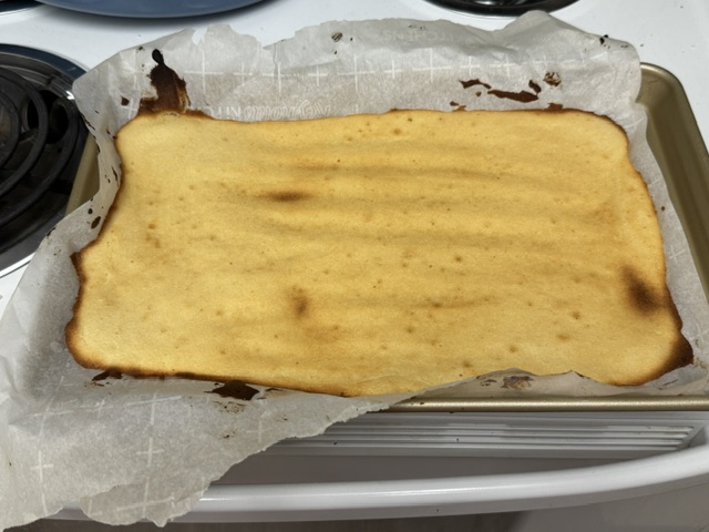 Couche de gâteau nature ; plus marron que les autres, et pas juste aux bords, mais pas du tout brûlée