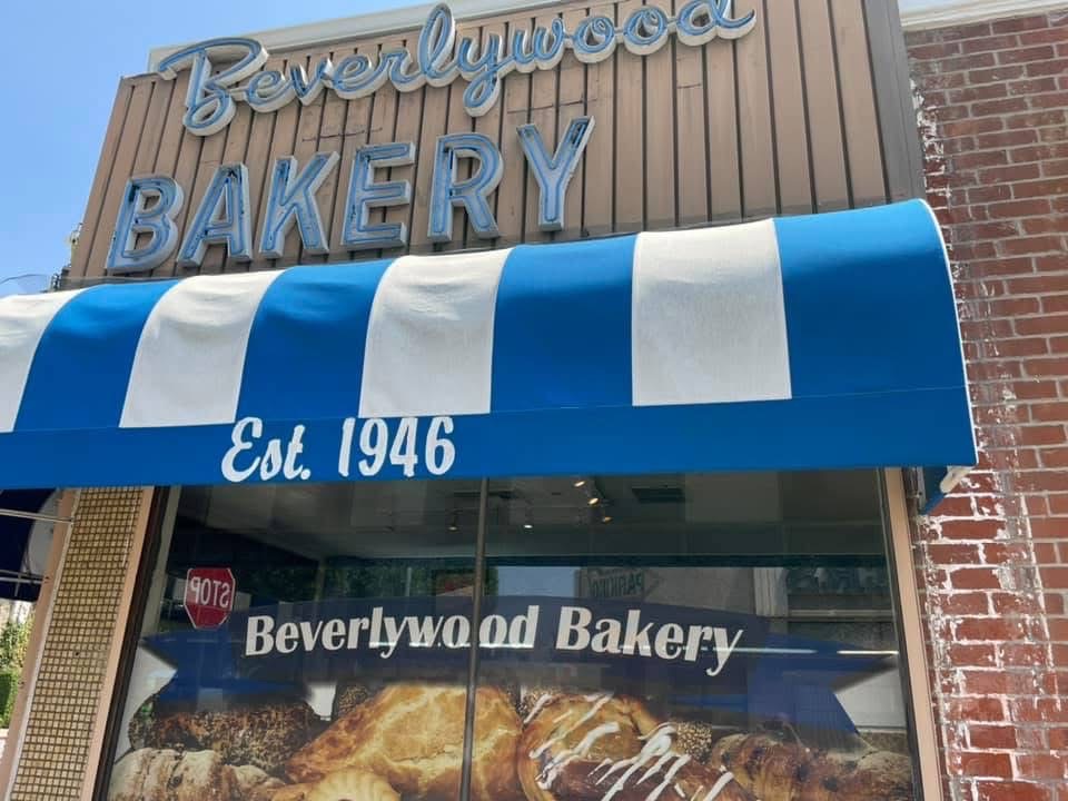 Porte de la boulangerie, avec une banne bleue et blanche qui dit "Beverlywood Bakery, établi 1946"