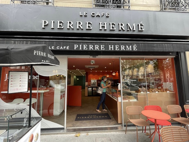C'est un café Pierre Hermé. La porte est ouverte et il y a un chariot à glaces juste à gauche, aussi de Pierre Hermé.