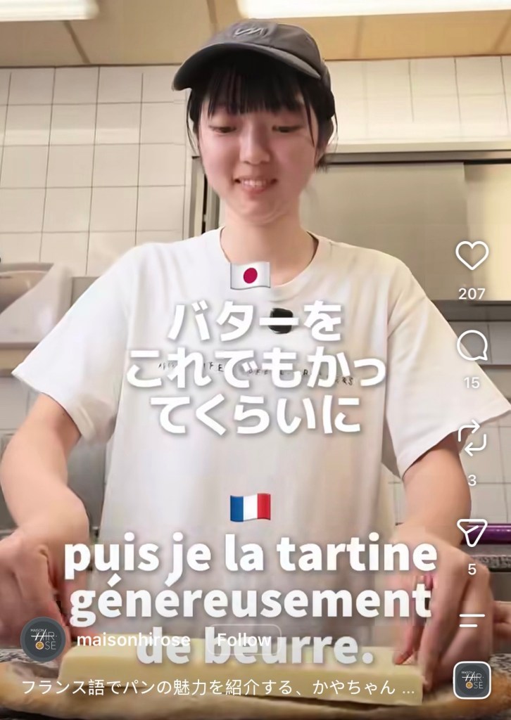 C'est une boulangère japonaise de peut-être 20 ans, dans le labo de sa boulangerie. Sur le plan de travail, il y a la moitié d'une baguette, coupée dans le sens de la longueur, sur laquelle elle pose un gros morceau de beurre.
