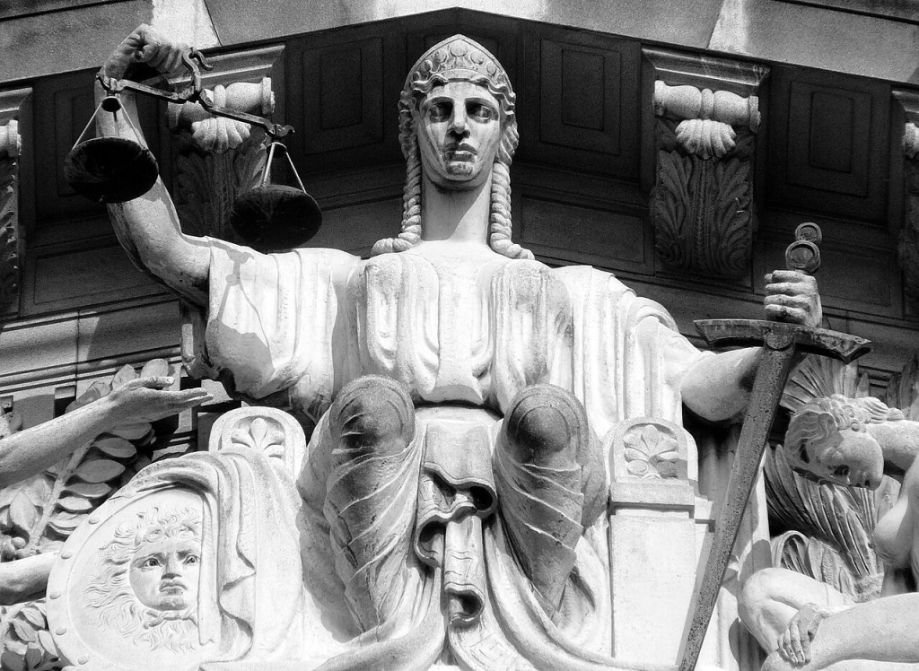 La Dame Justice en marbre. Dans la main droite, une balance ; la gauche, une épée. Mais les yeux sont pleinement ouverts.