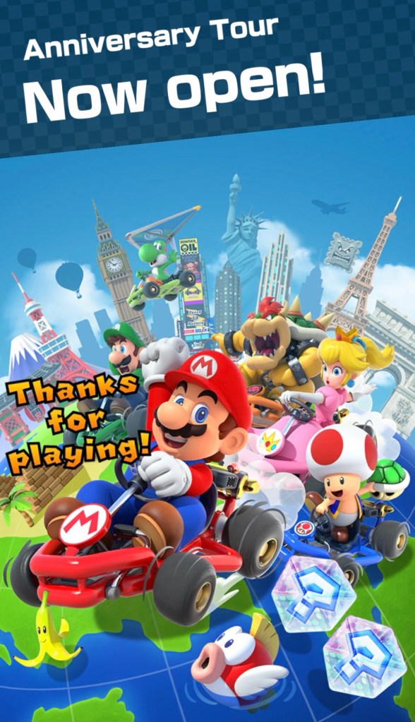 C'est Mario, Luigi, la Princesse Peach et Bowser dans des karts en premier plan -- en arrière plan, il y a des monuments des villes autour du monde : la Tour de Tokyo, Big Ben, Times Square, l'hôtel Marina Bay Sands à Singapour et la Tour Eiffel.