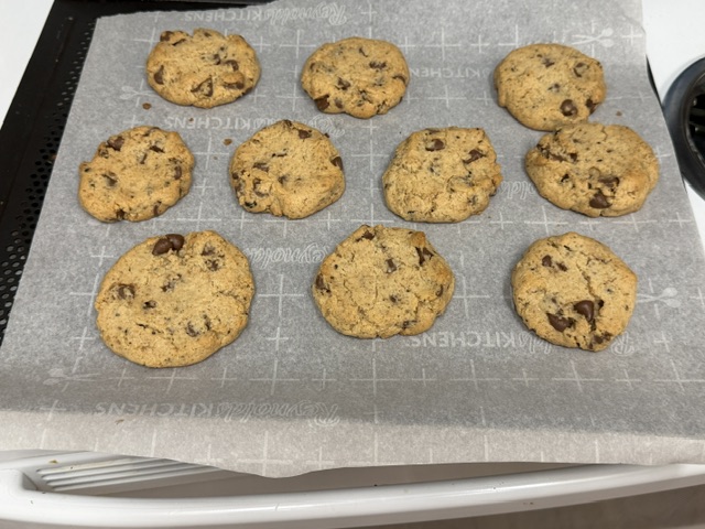 Cookies cuits sur le papier ; ils ont un peu gonflé et sont légèrement bruns -- pareils aux cookies du tapis