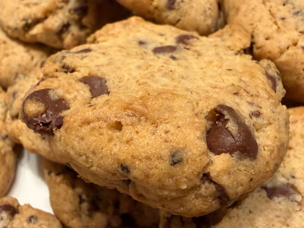 Un cookie en gros-plan, toujours sur l'assiette avec les autres, pour montrer de proche la texture des pépites de chocolat -- molles, mais pas fondues