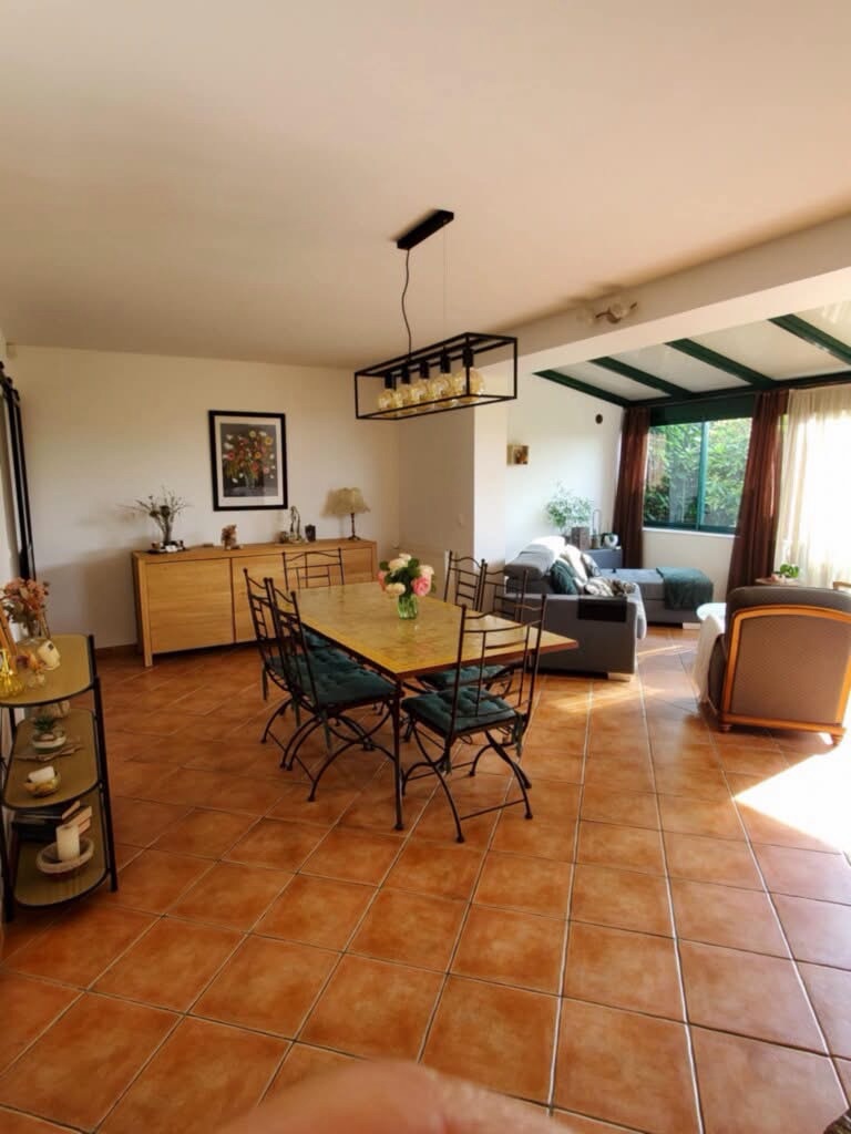 Salle à manger ultra-moderne -/ du carrelage, un chandelier rectangulaire en fer, des meubles très récents en bois, un canapé, etc.