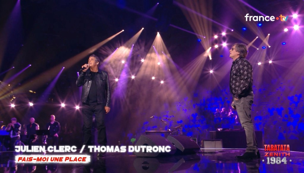 À gauche, Julien Clerc. À droite, Thomas Dutronc avec une chemise hyper-moche, noir avec des étoiles de 5 points en gris.