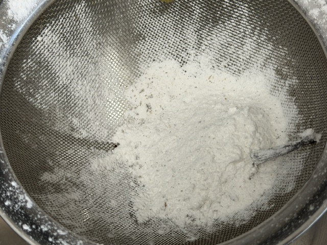 Tamis plein de sucre et le bout d'une gousse