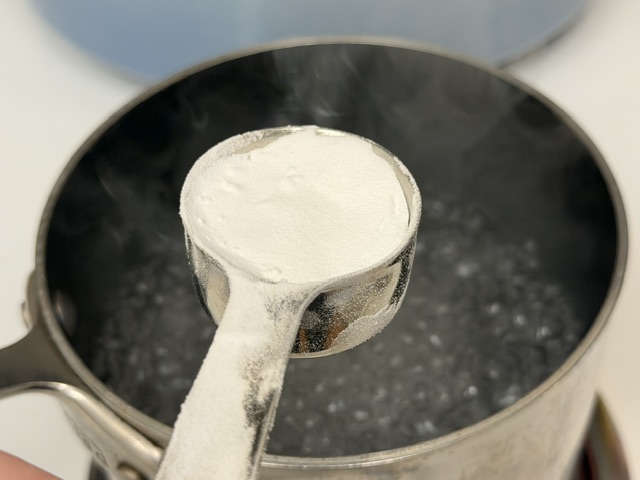Cuillère de bicarbonate de soude posée au-dessus de la casserole