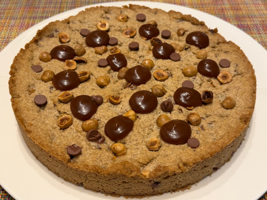 Cookie entier sur une grosse assiette. Le caramel a été poché en petits cercles ici et là sur le haut